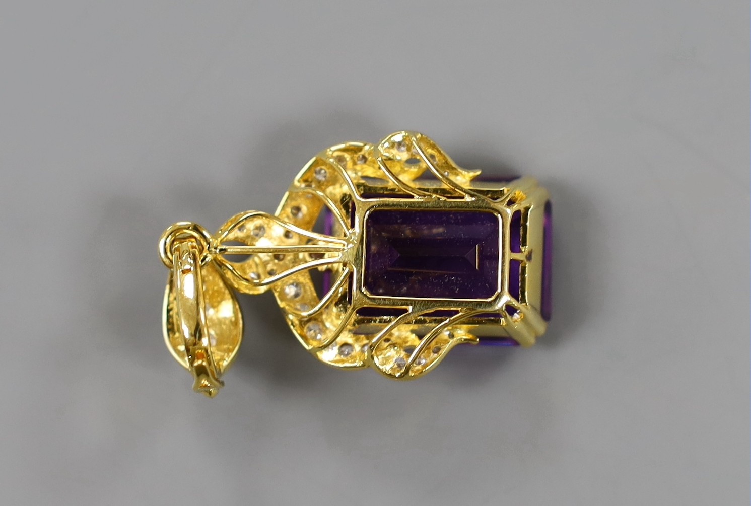 A modern yellow metal, emerald cut amethyst and diamond cluster set drop pendant, 45mm, gross weight 13.5 grams.